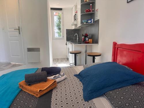 sypialnia z łóżkiem z niebieskimi poduszkami i kuchnią w obiekcie Studio and gallery w Cannes