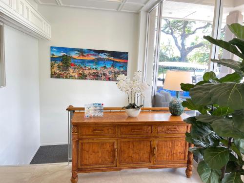a room with a wooden cabinet and a painting on the wall at Maui Eldorado Condo C101 in Kaanapali