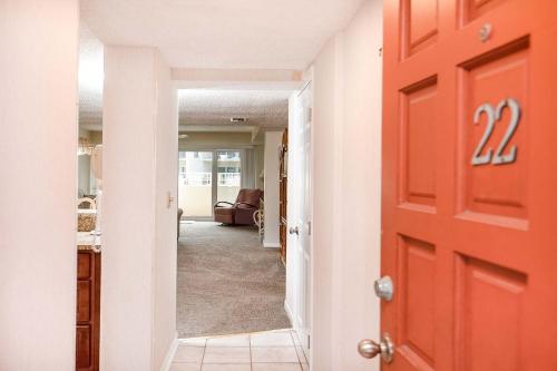a red door leading into a hallway with a living room at Pier Point South Ocean View Condo B-22 in Saint Augustine Beach