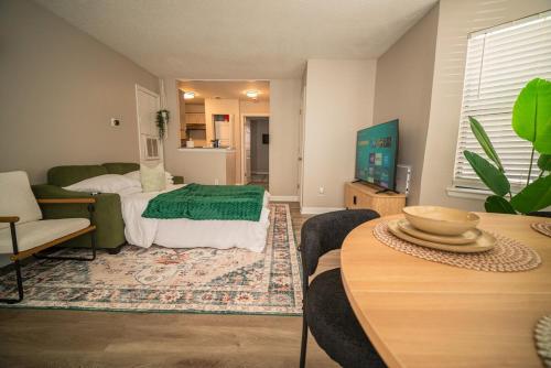 a living room with a bed and a table at Stylish & Cozy Retreat with Backyard & Parking in Charlotte