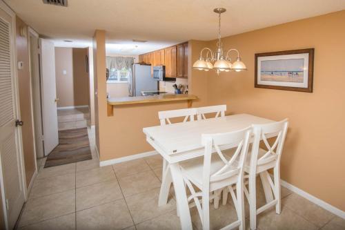 a kitchen and dining room with a white table and chairs at Pier Point South Ocean View Townhouse Condo B-20 in Saint Augustine Beach