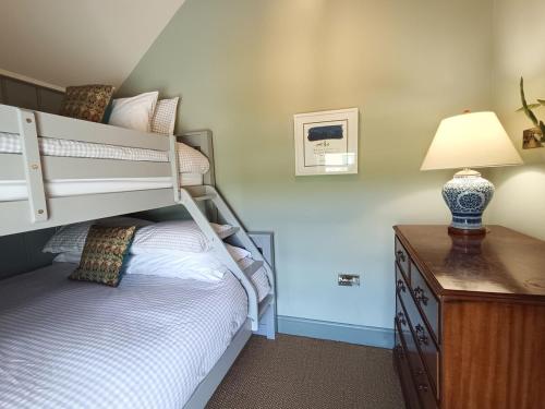 a bedroom with a bunk bed with a lamp and a dresser at 100 year old family farmhouse in Oldcastle
