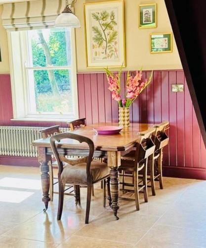 a dining room table with chairs and a vase of flowers at 100 year old family farmhouse in Oldcastle