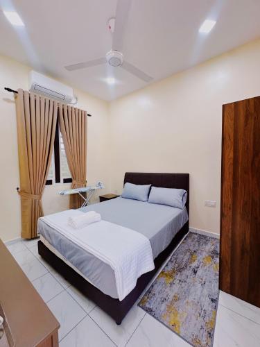a bedroom with a large bed and a television at Tokwan Homestay, Alor Setar Kedah in Alor Setar