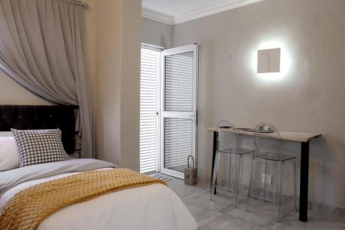 a bedroom with a bed and a table and a window at Simply The Choice Manor in Panorama