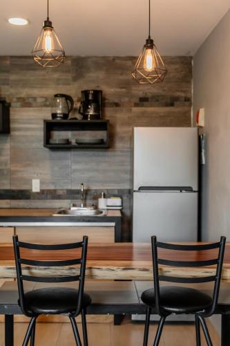 a kitchen with a table and two chairs and a refrigerator at CASA NAMI- Cancún Beachside Suites in Cancún