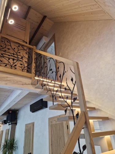 a spiral staircase in a house with a metal tree sculpture at Baltasis beržas 