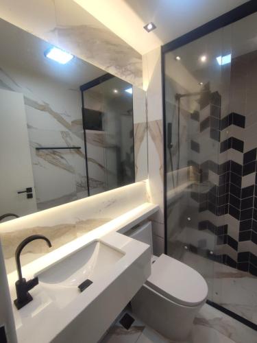 a bathroom with a toilet and a sink and a shower at Apartamento 2 Quartos , Ananindeua para C0P30 in Ananindeua