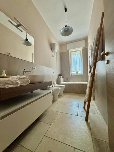 a bathroom with a sink and a toilet and a mirror at Villa Raffaele in Trani