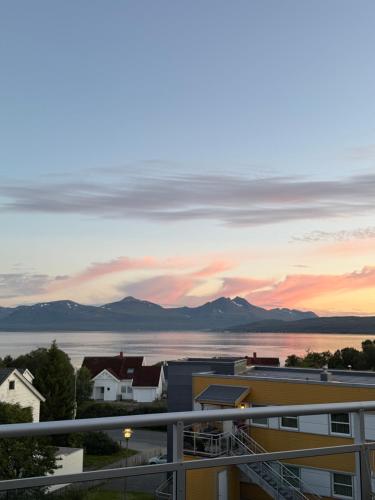 a view of the ocean from a balcony at sunset at Arctic Homestay with Northern light view room in Tromsø