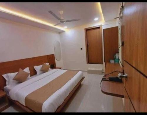 a bedroom with a large bed with a ceiling at HOTEL KONARK in in Vastral