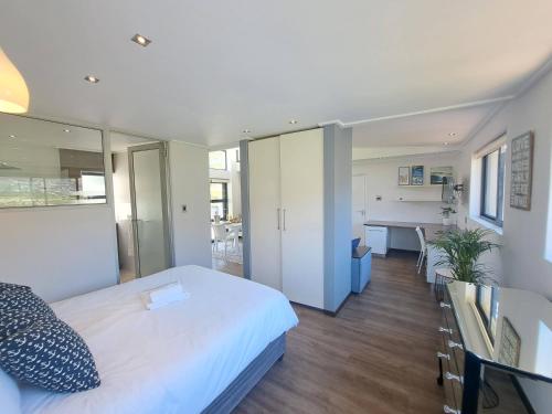 a bedroom with a bed and a desk and a table at Beach Holiday Accommodation in Hout Bay