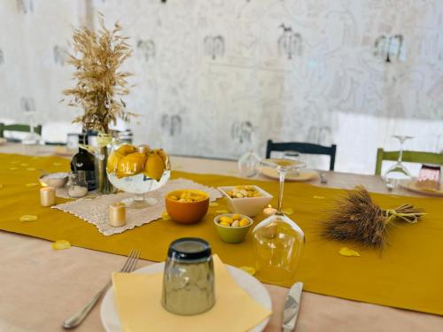 a table with a yellow table cloth with food on it at Masseria Sant'Agapito in Lucera