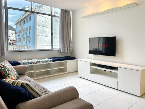 Una sala de estar con un sofá y un televisor de pantalla plana. en Edifício Dez de Março, en Río de Janeiro