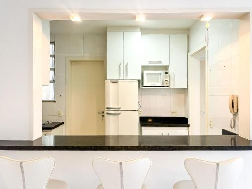 Una cocina con gabinetes blancos y electrodomésticos blancos. en Edifício Dez de Março, en Río de Janeiro