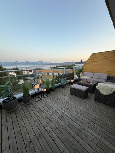 a deck with furniture and plants on a building at Arctic Homestay with Northern light view room in Tromsø