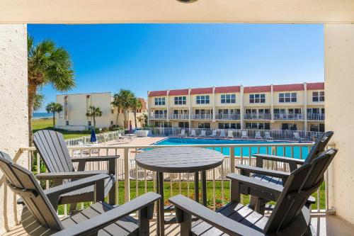a patio with chairs and a table and a pool at Pier Point South Ocean View Condo B-18 in St. Augustine