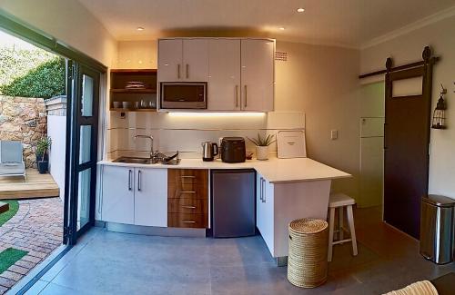 a kitchen with white cabinets and a counter top at Beach Holiday Accommodation in Hout Bay