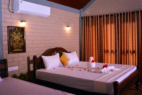 a bedroom with a bed with white sheets and a window at Pearl Cave Cabanas & Resturant in Tangalle