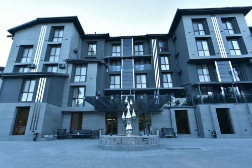 a large building with a fountain in front of it at Stillaterm SPA in Mineralni Bani