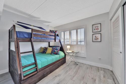 a bedroom with a bunk bed and a desk at Pier Point South Ocean View Condo D-44 in Saint Augustine Beach