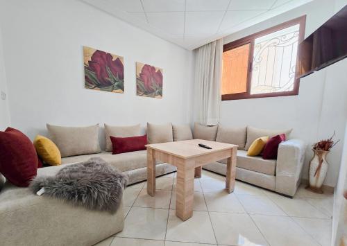 una sala de estar con un sofá y una mesa en Luxury Renovated Apartment in Agadir, en Agadir