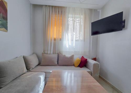 Una sala de estar con un sofá y un televisor de pantalla plana. en Luxury Renovated Apartment in Agadir, en Agadir
