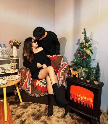 a man and woman kissing on a bed with a christmas tree at One dayภูทับเบิก in Ban Maeo Thap Boek