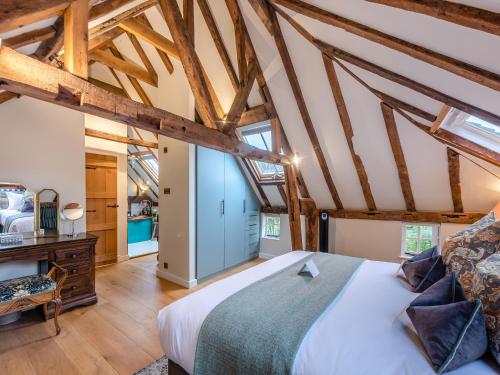 a bedroom with a large bed and wooden ceilings at Mousehall Oast in Wadhurst