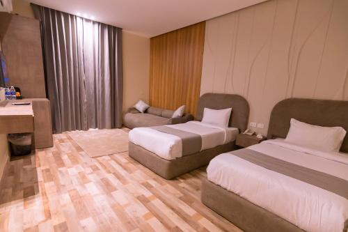 a hotel room with two beds and a couch at Elevana Boutique hotel in Cairo