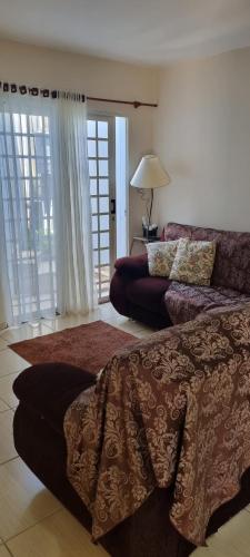 a living room with a bed and a couch at Casa com ampla área de lazer há 10 minutos do Santuário de Aparecida in Guaratinguetá