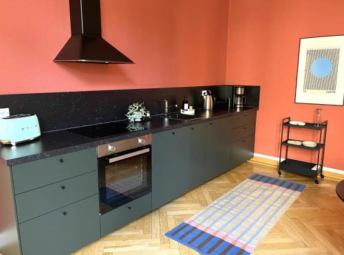 a kitchen with a black counter and an orange wall at 170qm 3 Schlafzimmer 2 Parkplätze 2 Bäder in Frankfurt/Oder