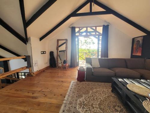 a living room with a couch and a large window at DesertDewEstate in Nanyuki