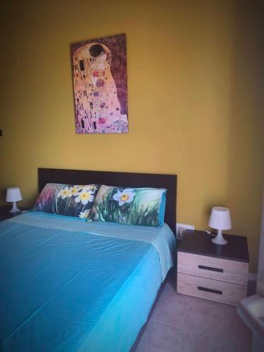 a bedroom with a blue bed with two lamps on it at Dimora Accorsi in Ferrara