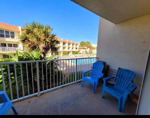 deux chaises bleues assises sur le balcon d'un condo dans l'établissement Pier Point South Ocean View Townhouse Condo D-45, à Saint Augustine Beach
