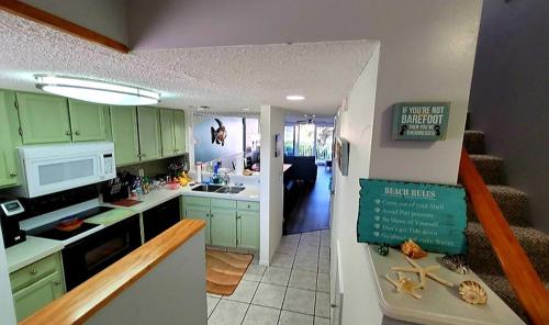 une cuisine avec des armoires vertes et un réfrigérateur blanc dans l'établissement Pier Point South Ocean View Townhouse Condo D-45, à Saint Augustine Beach