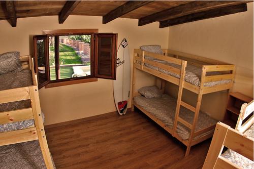 una habitación con tres literas y una ventana en Surf House, en Callao Salvaje