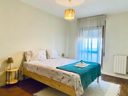 a bedroom with a bed with a blue blanket and a window at Serene Coastal Retreat with king Beds & Pool in Lavra in Lavra