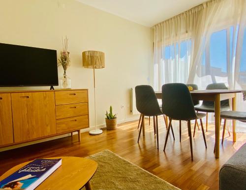 a living room with a table and chairs and a television at Serene Coastal Retreat with king Bed & Pool in Lavra in Lavra