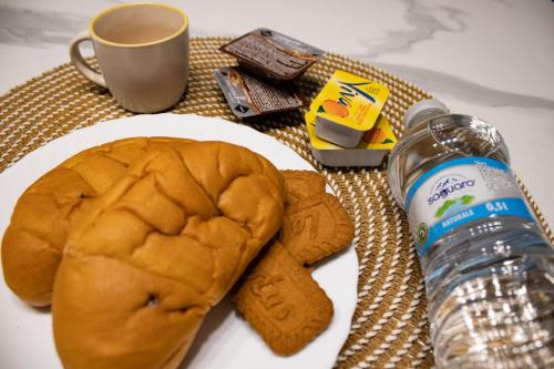 a plate with a sandwich and a bottle of water at B&B San Savino in Piacenza