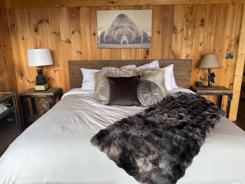 a bed with a black and white blanket on it at Classy Bear Cabin in Gatlinburg