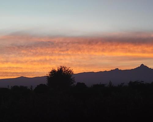 a sunset with mountains in the background at DesertDewEstate in Nanyuki