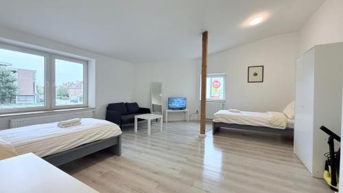a bedroom with two beds and a chair and a window at Monteurwohnung Brunsbüttel zentrale Lage mit Parkplatz & Schleusenblick in Brunsbüttel