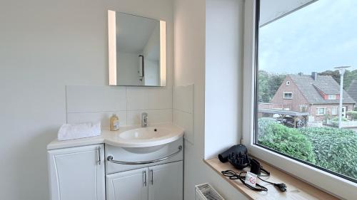 a bathroom with a sink and a window at Monteurwohnung Brunsbüttel zentrale Lage mit Parkplatz & Schleusenblick in Brunsbüttel