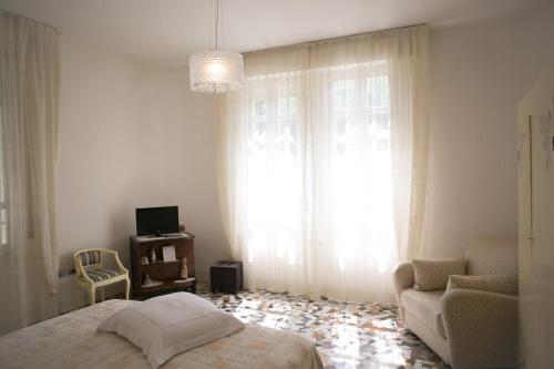 a bedroom with a bed and a chair and a window at B&B Casa Dei Grilli in Longiano