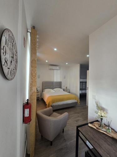 a bedroom with a bed and a clock on the wall at AquaChaves Apart Studios in Chaves