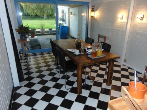 a dining room with a table and a checkered floor at Dutchies-dk in Væggerløse