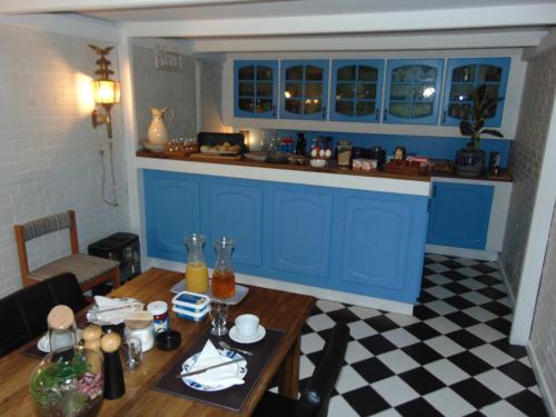 a kitchen with blue cabinets and a wooden table at Dutchies-dk in Væggerløse