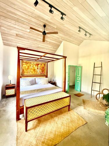 a bedroom with a large bed and a wooden ceiling at Tropicana Hideaway Hikkaduwa in Hikkaduwa