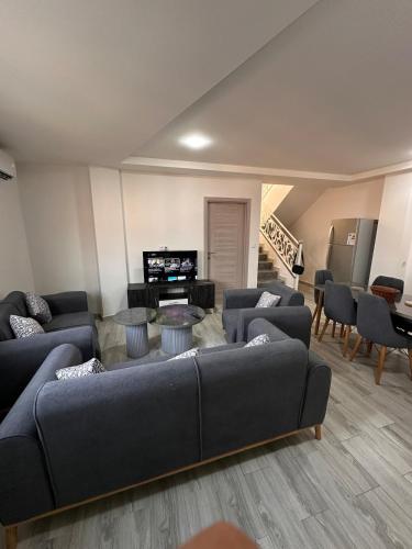 a large living room with couches and a television at Duplex with a view of Yema Gouraya in Bejaïa